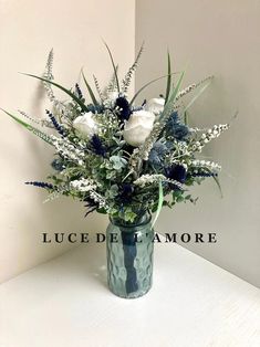 a vase filled with white and blue flowers