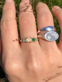 This Earthy Opal Engagement Ring is the perfect way to wrap your hands in love. These Rings are made with genuine Raw free-formed Opal, emerald and aquamarine in their natural state. It's crafted in a Solid Sterling silver/14k/18k Gold Specification: Gemstone: Raw Opal, emerald, aquamarine Center Opal Size: 4.5mm*5.5mm Materials: Solid Sterling Silver, Solid 14k/18k Gold Style: Engagement Ring *Gems: The raw gems natural hues vary, adding an organic touch to your ensemble. I'll try to select the Multi-stone Emerald Diamond Ring For May Birthstone, Heirloom Jewelry With Gemstone For May Birthstone, Heirloom Gemstone Jewelry For May Birthstone, Heirloom May Birthstone Jewelry With Gemstone, Green Three Stone Fine Jewelry, Heirloom Style Opal Ring Gift, Unique Green Birthstone Jewelry, Heirloom Style May Birthstone Jewelry For Promise, Adjustable Green Multi-stone Ring