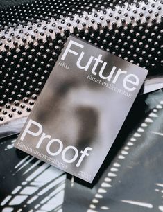 a book sitting on top of a black table next to a metal grate with rivets