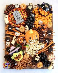 an assortment of halloween treats arranged on a wooden board with the words, i am the magnolia mercantile's