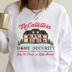 "McAllister's Home Security Crewneck Sweater Celebrate the hilarious adventures of Kevin McAllister from the holiday classic Home Alone with our special sweater. This unique and playful sweater brings a touch of Christmas magic to your wardrobe. Why We Love It:  ♥️ Home Alone-Inspired: The sweater features a design inspired by Kevin's adventures as he's left home alone during Christmas time. It captures the whimsy and charm of the movie, making it a delightful and recognizable addition to your h Kevin Mcallister, Christmas Nostalgia, Security Shirt, Christmas Movie Shirts, Movie Making, Holiday Attire, Comfy Sweater, Holiday Wardrobe, Movie Shirts