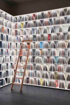 a ladder leaning against a wall full of records