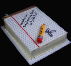 a cake with writing and a pencil on it