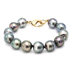 A stunning selection of twelve round Tahitian Pearls circle the wrist for a stunning statement and close with a 18k Yellow Gold clasp. Details: Length: 8.75" Pearl Size: 12.4-17 mm Pearls strung with black, handmade twisted White Gold toggle and Diamond tips. Alchemy's Bio & Catalog can be found here. Please contact us for resizing options, special order inquiries, or any other questions. Luxury Tahitian Pearl White Gold Jewelry, Luxury White Gold Tahitian Pearl Jewelry, Classic Tahitian Pearl Jewelry With Round Beads, Classic Jewelry With Hidden Clasp For Gift, Classic Formal Jewelry With Hidden Clasp, Round Tahitian Pearl Jewelry With High Luster, Tahitian Pearl Jewelry With High Luster, Tahitian Pearl Jewelry With High Luster Beads, High Luster Tahitian Pearl Round Beads Jewelry