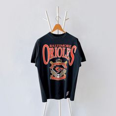 90s Baltimore Orioles MLB t-shirt/ L * PLEASE READ BEFORE PURCHASE * PLEASE consider the PHOTOS before making the decision * The images may DIFFER in appearance from the actual product because we took pictures under daylight.  * PLEASE send your PHONE NUMBER after your purchase for the shipping company to contact you X No returns X No refund Condition : 9/10 More details : look at the pictures  Brand : Nutmeg mills Size : L Pit to pit/ Chests : 22/44 inches  Length : 29.5 inches  Material : cott Black Short Sleeve Throwback T-shirt, Streetwear Vintage Print Short Sleeve T-shirt, Vintage Print Short Sleeve T-shirt For Streetwear, 90s Style Black T-shirt With Vintage Print, Black 90s Vintage Print T-shirt, Throwback Short Sleeve Tops With Screen Print, Throwback Graphic Print Short Sleeve Tops, Throwback Style Short Sleeve Graphic Print Tops, Throwback Style Short Sleeve Tops With Graphic Print