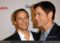 two men standing next to each other on a red carpet