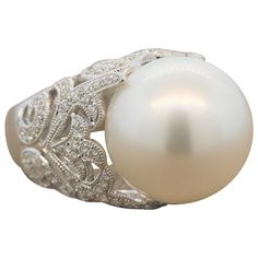 A luminous 15.5mm-16mm South Sea pearl surrounded by 0.75 carats of VS quality diamonds. The colorless round cut diamonds are set in a lavish 18K white gold filigree ring with a milgrain design. Ring Size 6.75 (Sizable) Filigree Ring Gold, Diamond Gold Ring, Pearl And Diamond Ring, Platinum Diamond Rings, Rose Gold Studs, Gold Cocktail Ring, Contemporary Ring, Colorless Diamond, Gold Cocktail