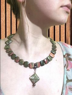 "Necklace and made of natural unakite. The length of the necklace from the Lobster's Claw lock to the pendant is 24 cm (9,4\"). The necklace consists of faceted rectangular unawite beads and copper beads. The necklace fits very comfortably in the neckline. You can be the star of the party with this set of Unakite. And the strong energy of the stone will protect you from envious glances.😉 According to Astrology, the unakite stone can neutralize the influence of negative energy, protects against Earthy Green Necklace For Festivals, Earthy Green Necklace For Festival, Bohemian Square Pendant Necklace For Jewelry Making, Earthy Green Gemstone Necklace, Bohemian Ocean Jasper Necklaces As Gifts, Bohemian Ocean Jasper Necklace For Gifts, Bohemian Ocean Jasper Necklaces For Gifts, Bohemian Ocean Jasper Necklace As Gift, Green Jasper Necklaces With Natural Stones