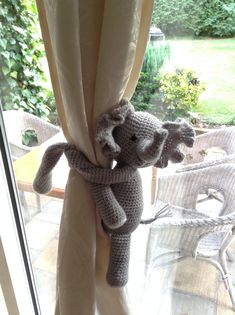 the stuffed elephant is hanging from the curtain