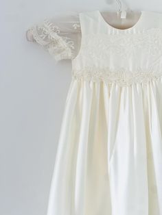 Beautiful and elegant baby girls' lace baptism dress. Two-piece set including a delicately embroidered short-sleeve gown with matching headband. Complete with a linen and cotton blend liner, to ensure comfort. Feel free to add one of our adorable shoes to complete the look. Cream Baptism Dress With Lace Bodice, Cream Lace Baptism Dress With Lace Trim, Cream Lace Patchwork Dress For Baptism, Cream Lace Dress For First Communion, Elegant Cream Lace First Communion Dress, Elegant Off White Lace Baptism Dress, Elegant Off-white Lace Baptism Dress, Cream Baptism Dress With Lace Sleeves, Cream Baptism Dress With Lace Patchwork