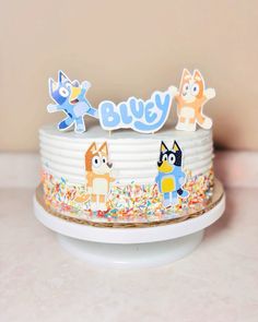 a birthday cake decorated with cartoon characters and sprinkles on a white plate