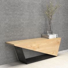 a wooden table sitting on top of a white floor next to a vase filled with flowers