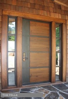 the front door to a home with stone flooring and wood trimmings on it