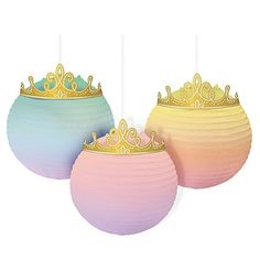 three paper lanterns with crowns on them are sitting next to each other in different colors