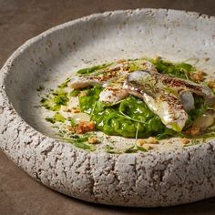 a white bowl filled with food on top of a table