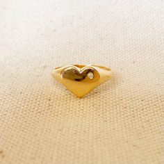 A cute heart with cubic zirconia accent to shiny your soul. 18k Gold Filled ring featuring a heart shaped polished top with a single micro pave Cubic Zirconia Stone. * Metal: 18k Gold Filled * Weights 1.0 grams * Hypoallergenic jewelry * Handcrafted in Brazil Learn how to care for your jewelry with these easy instructions. Properly handling and caring for your ArtBossa jewelry is essential in maintaining its pristine condition. 1. Keep your gold-filled jewelry away from chemicals and cleaning pr Heart Plate, 18k Gold Chain, Top Rings, Hypoallergenic Jewelry, Gold Filled Ring, Jewelry Manufacturers, Emerald Jewelry, Hamsa Hand, Cuff Bangles