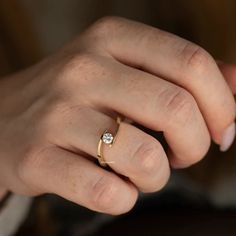 a woman's hand with a diamond ring on it