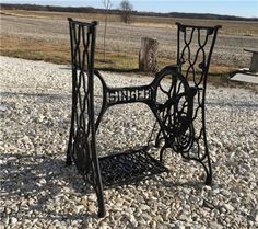 an old sewing machine is sitting on the gravel