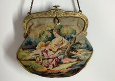 "This is a stunning high quality micro petit point Austrian bag circa 1920s. The imagery differs on both sides depicting a detailed setting. Two figures sit side by side fishing by the river on a bed of foliage with trees in the background. The opposite side continues with a small castle also flanked by trees and foliage. The colours are multitude, in varying shades of greens, blues, ochre, orange, brown, and pinks...  Gold carved metal frame with a doubled chain handle. Condition- there is some Aubusson Tapestry, Tapestry Purse, Jewel Frames, Tapestry Handbags, Book Purse, Tapestry Bag, Vintage Tapestry, Vintage Purses, Beaded Purses