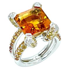 A truly stunning work of art! This Madeira Citrine fires up with light. It is emerald cut and weighs 6.00 carats, set with four Diamond and Citrine pave prongs, with a pave Citrine split shank in 18K white gold. There are 0.26 carats in round brilliant Diamonds, with an additional 2.00 carats in round cut Citrines. The shank is stamped "750". The ring is currently a size 6.25, and can be adjusted. Offered by Charles Schwartz & Son Jewelers. Luxury Multi-stone Yellow Gemstones, Luxury Multi-stone White Gold Topaz Ring, Luxury White Gold Topaz Ring With Multi-stone, Luxury White Gold Multi-stone Topaz Ring, Luxury Yellow Multi-stone Gemstones, Luxury Yellow Sapphire Ring, Luxury Radiant Cut Sapphire Ring, Luxury High Luster Gemstones For Formal Occasions, Luxury Yellow Sapphire Multi-stone Ring