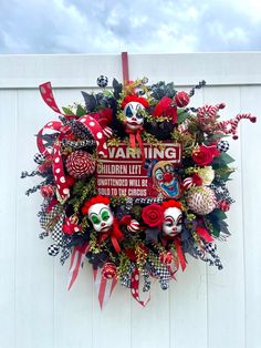 a wreath that is hanging on the side of a building with red and white decorations