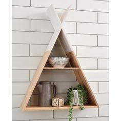 a wooden shelf with two triangular shelves on it and some plants in front of it