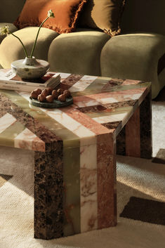 a marble coffee table sitting on top of a carpeted floor next to a couch