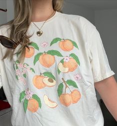 Calling all Georgia Peaches! This shirt is a summer wardrobe staple. Give it as a gift to someone sweet or get it for yourself. You deserve a *little treat* 🍑 At Studio Sohl, we are obsessed with the perfect casual tee. Whether you're chilling at home, running errands, or looking to add a touch of effortless chic to your workday wardrobe, this tee has got you covered baby 🫶🏼 🪩 Gildan 64000 Unisex Tshirt 🪩 100% ring-spun cotton, super soft!  🪩 We recommend ordering 1-2 sizes up for an effortless, oversized look ⭐️Questions or looking for something custom? Send us a message! ⭐️ RETURNS & SHIPPING: As our items are made to order, we are unable to accept returns. However, if there is an issue with the printing on your order, kindly send us a photo and we will gladly offer a refund or rep Playful Spring T-shirt For Everyday, Playful Everyday T-shirt For Spring, Casual Peach T-shirt With Graphic Print, Peach Short Sleeve T-shirt For Summer, Casual Screen Print T-shirt For Brunch, Summer Brunch T-shirt With Screen Print, Sweet Short Sleeve Tops With Fruit Print, Cute Peach T-shirt With Crew Neck, Spring Tops With Funny Print For Day Out