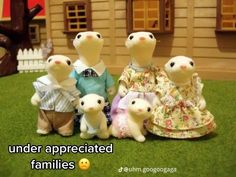 a group of stuffed animals standing next to each other in front of a doll house