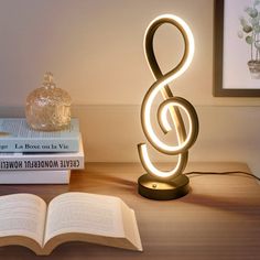 a lamp that is on top of a table next to some books and an open book