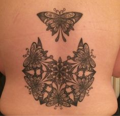 the back of a woman's stomach with an intricate tattoo design on her side