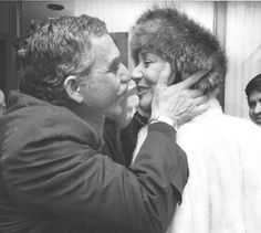 a man and woman hug each other in front of a mirror while wearing fur hats