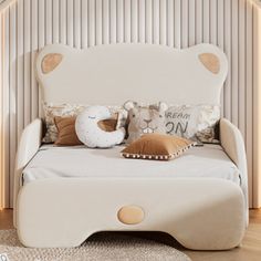 a white bed with pillows and stuffed animals on it's headboard in a bedroom