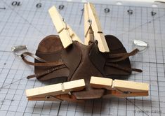 a pair of shoes are being made out of wood and leather with clothes pins attached to them