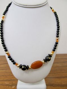 - Vintage black and orange plastic beaded necklace - Small round with larger accent beads - 50 inch necklace - Clean and in good condition K 3304 Vintage Black Beaded Necklace With Colorful Beads, Black Vintage Beaded Necklaces With Colorful Beads, Black Oval Beaded Necklaces, Black Necklace With Colorful Oval Beads, Black Necklaces With Colorful Oval Beads, Vintage Black Necklace With Oval Beads, Orange Necklace With Black Round Beads, Vintage Black Gemstone Beads Necklace, Vintage Black Beaded Necklace With Gemstone Beads