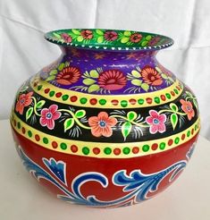 a colorful painted vase sitting on top of a table