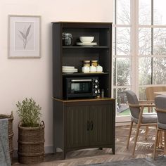 a kitchen area with a microwave, table and chairs in it's centerpiece