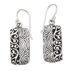 Half fingerprint motif half curling vine Wayan Asmana's dangle earrings are 100% fun. Balinese artisans use sterling silver to create the earrings engraving the precious metal with two distinct patterns in a combination finish. Engraved Sterling Silver Adjustable Earrings, Silver Artisan Earrings With Artistic Design, Sterling Silver Artistic Earrings For Gift, Artisan Silver Earrings With Artistic Design, Artistic Sterling Silver Earrings As Gift, Artistic Sterling Silver Earrings, Artisan Sterling Silver Etched Earrings, Etched Sterling Silver Dangle Earrings, Artisan Etched Sterling Silver Earrings