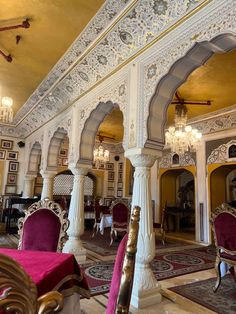 an ornately decorated room with chairs and chandeliers