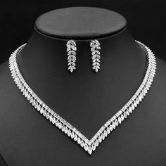 a necklace and earring set on a mannequin headdress in black and white