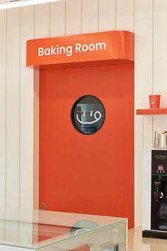 an orange sign that says baking room in front of a white wall and red door