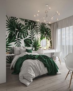 a bedroom decorated in white and green with palm leaves on the wall