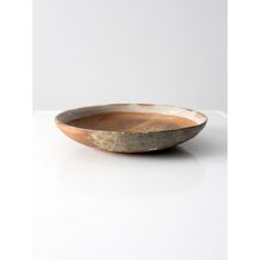 a wooden bowl sitting on top of a white table