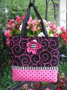 a pink and black bag with flowers in it