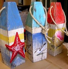 three small wooden blocks with starfishs and seashells painted on them sitting on a table