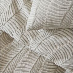 an up close shot of the textured fabric on a white bed sheet with wavy lines