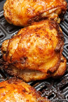 three pieces of chicken sitting on top of a grill