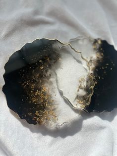 a piece of glass with gold flecks on it sitting on a white sheet