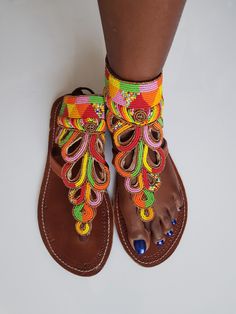 Maasai sandals made with high quality black leather and colorful fine beads. Perfect for outdoor summer events , beach wear , festivals , African themed events etc. Comes with laces to tie at the back. The sandals are true to size. Buy multiple items and pay shipping for one item Only. Back to my shop; https://www.etsy.com/shop/TribalTess?ref=seller-platform-mcnav Beaded Leather Sandals, African Sandals, Tie Sandals, African Earrings, Beaded Sandals, Outdoor Summer, Themed Events, Maasai, Black Leather Sandals