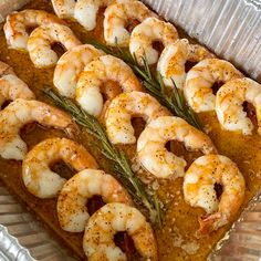 cooked shrimp and garlic in a pan with rosemary garnish